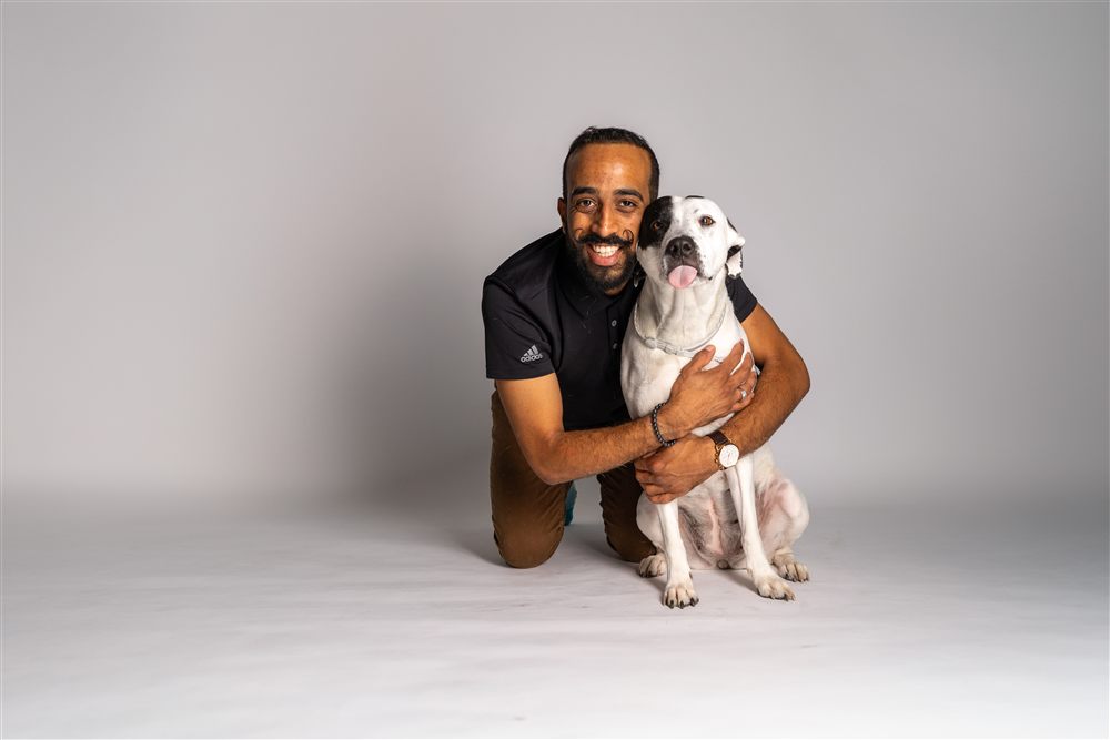 Shady, founder of Shady Waggers, hugging his dog Moo